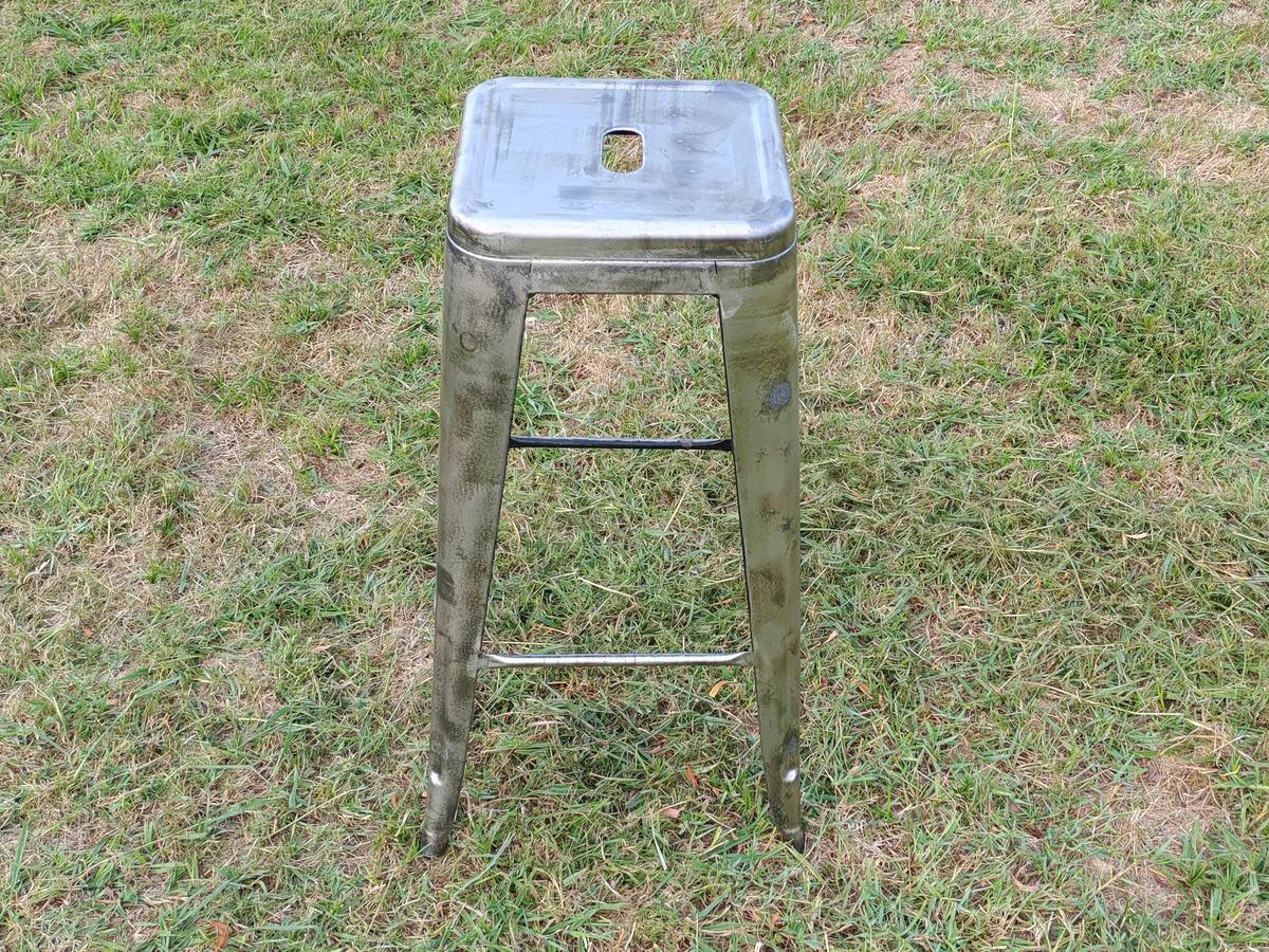 Tabouret métallique après décapage laser : la rouille et l'ancienne peinture ont disparu